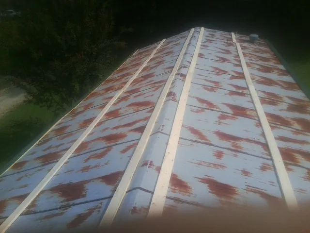 Rusted metal roof panels with new wood purlins before replacement — Storm Damage Roof Repair in Cummington by Roofing Brothers