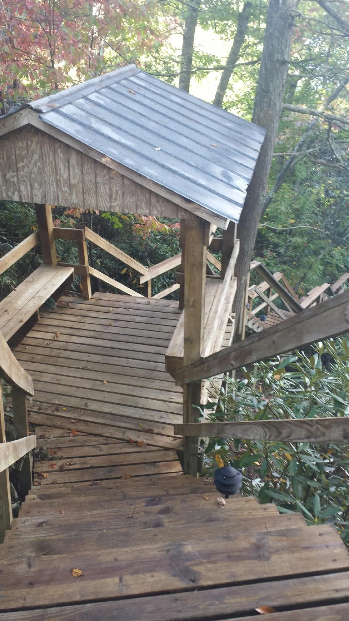 Metal roofed shelter over wooden steps on a wooded walkway — Skylight Repair & Installation work by our crew in Cummington
