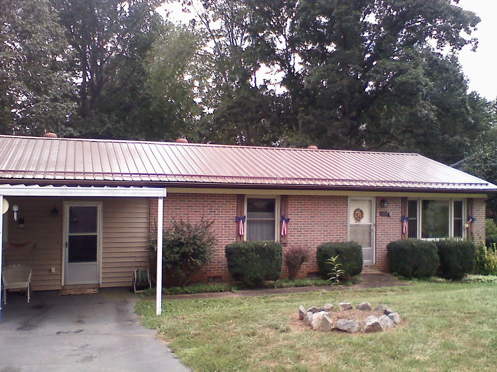 Bronze metal roof and carport on a brick ranch home — Roof Repair work by our crew in Cummington